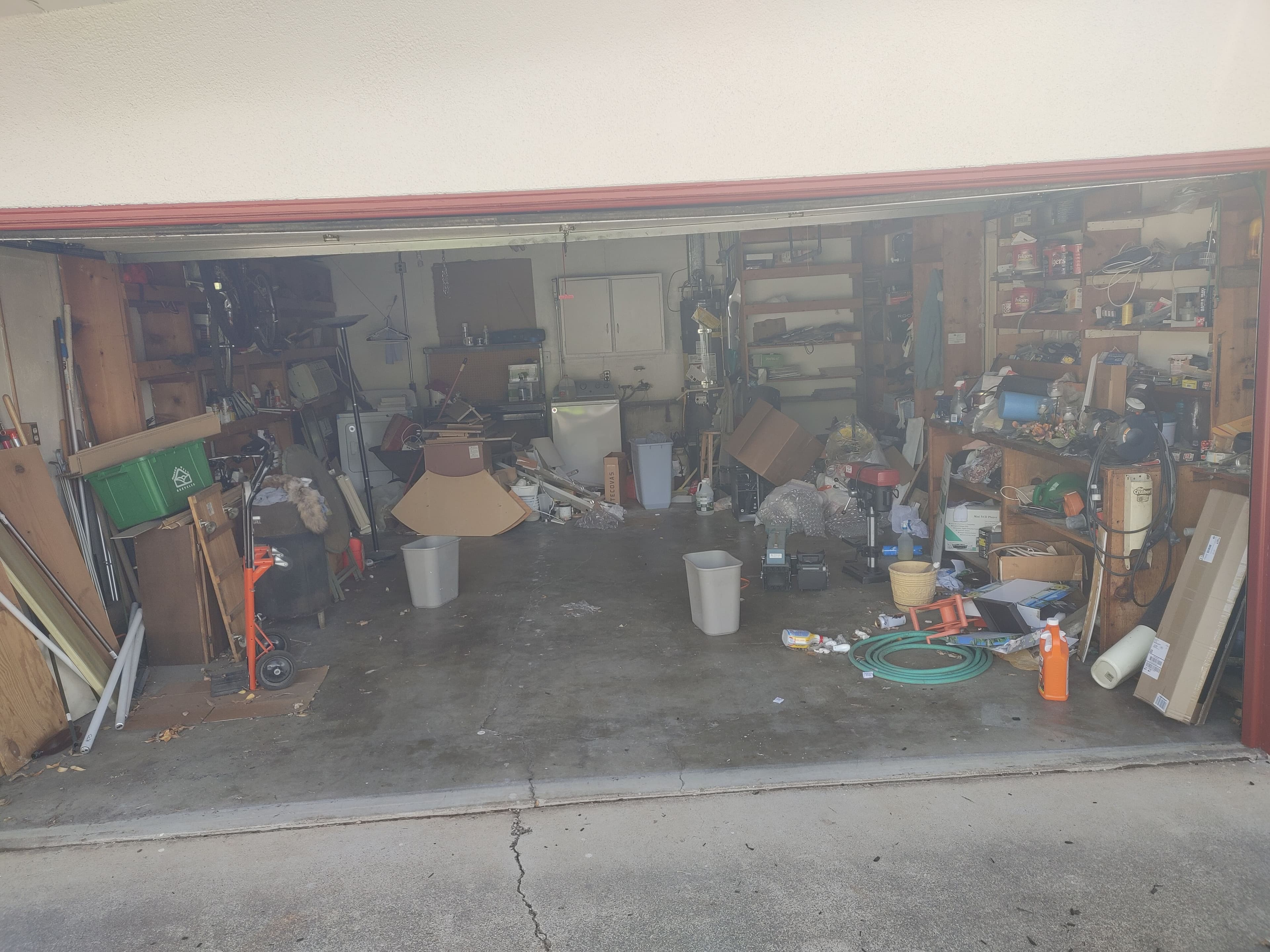 Cluttered garage filled with tools, boxes, and scattered items, needing organization.