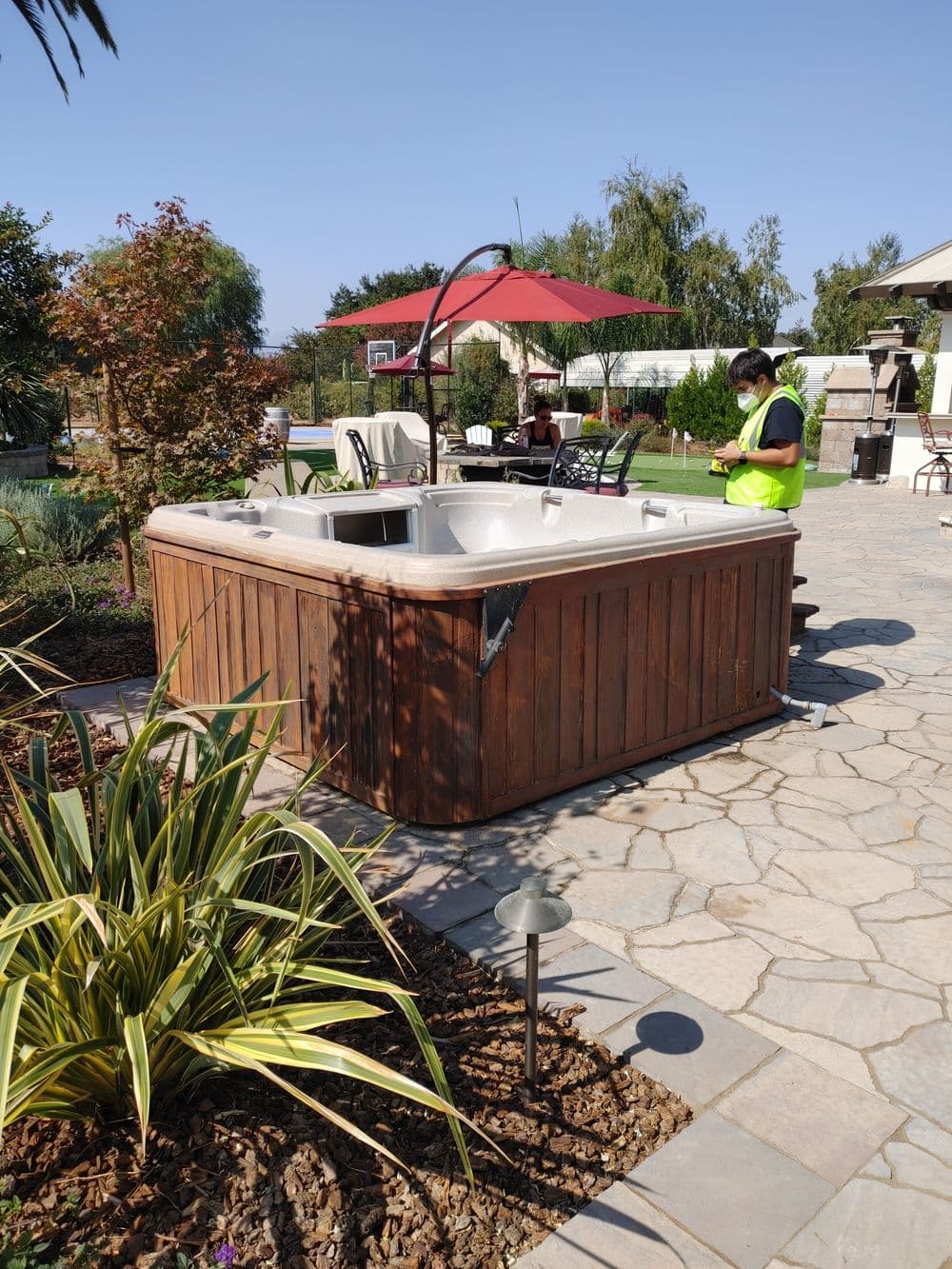 Hot tub installation in a landscaped outdoor area with plants and leisure seating.